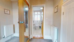 a bathroom with a toilet and a hallway with a door at Stunning 2 Bed Georgian Apartment in North Walsham