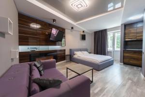 a living room with a purple couch and a bed at Central Apartments Palats Sportu Area in Kyiv