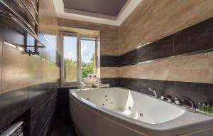 a bathroom with a large tub and a window at Central Apartments Palats Sportu Area in Kyiv +124 photos