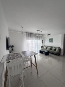 a living room with a table and chairs and a couch at Royal Park A&7 Deluxe, swim pool - by G&P suites in Eilat