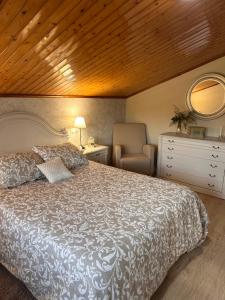 a bedroom with a large bed and a chair at Turismo Casa Benito in Villanueva de Arosa