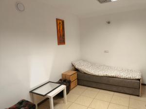 a small bedroom with a bed and a table at Noclegi w mieście in Kozienice