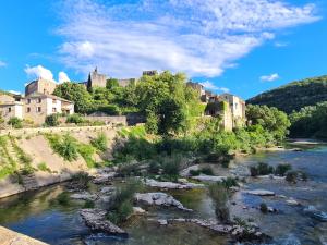 a view of a river with a castle in the background at Le Petit Chêne in Orgnac-lʼAven