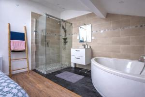 a bathroom with a shower and a tub and a sink at Les Cœurs de Ribérac - Hyper centre - Climatisation - Wi-Fi in Ribérac +40 photos