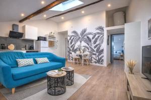 a living room with a blue couch and a table at Les Cœurs de Ribérac - Hyper centre - Climatisation - Wi-Fi in Ribérac