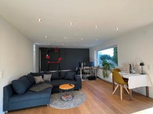 a living room with a blue couch and a table at Kappelblick Apartment ohne Küche - mehr als nur ein Doppelzimmer in Burgthann