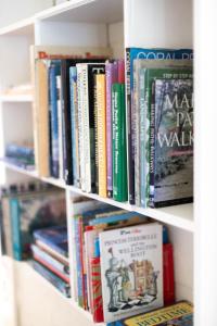 a book shelf filled with lots of books at Douglas Drift Cottages in Underberg