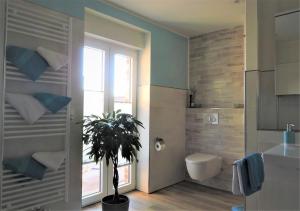 a bathroom with a toilet and a potted plant at Apartment am Anker in Uchte