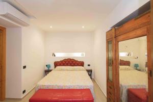 a bedroom with two beds and a red bench at Gioeni 23 in Cefalù