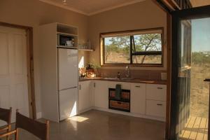 a kitchen with a white refrigerator and a window at Valley View Escape in Uitkeer +14 photos
