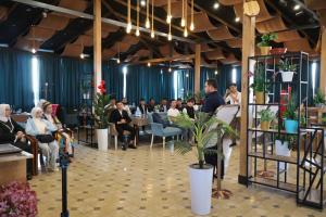 a group of people sitting at tables in a restaurant at Almaz PLAZA in Tashkent