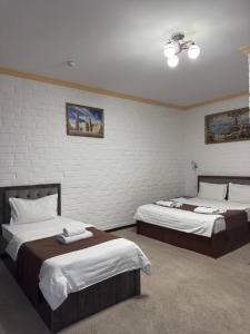 a bedroom with two beds and a brick wall at Almaz PLAZA in Tashkent +36 photos