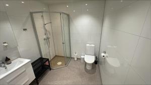 a bathroom with a shower and a toilet and a sink at Stayover Lista in Farsund +26 photos