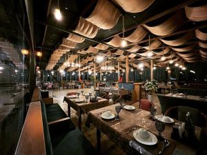 a restaurant with tables and chairs in a room at Almaz PLAZA in Tashkent