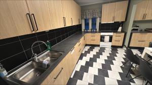 a kitchen with a sink and a checkered floor at Stayover Lista in Farsund