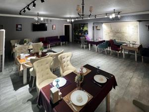 a restaurant with tables and chairs in a room at Almaz PLAZA in Tashkent