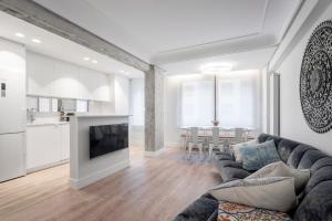 sala de estar con sofá y TV en Apartamento Zurriola Luxury - Surf Beach con aire acondicionado, en San Sebastián