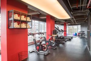 a gym with red walls and exercise bikes at Sonesta Hotel Bogotá in Bogotá
