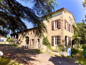 an old stone building with a tree in front of it at La Demeure des Fleurs in Caillavet