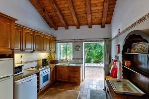 a kitchen with wooden cabinets and a large window at Quinta Velha by GT House in Portimão