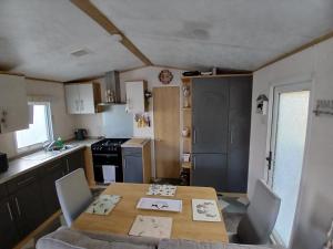 a kitchen with a table and chairs and a table and a kitchen at The Robin's Nest in Fochabers
