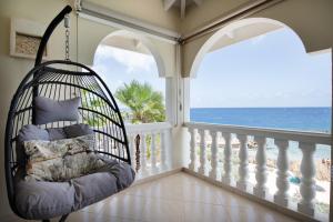 a porch swing with a view of the ocean at Curacao Luxury Holiday Rentals in Willemstad