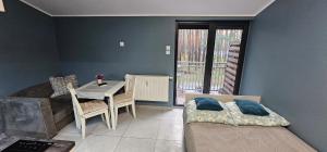 a bedroom with a table and a bed and a desk at Apartament Słoneczna in Radzyń