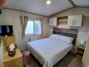 a small bedroom with a bed and a window at The Robin's Nest in Fochabers