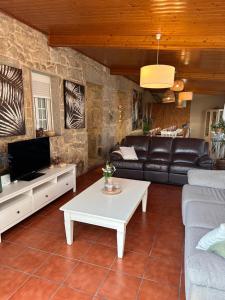 a living room with a couch and a tv at Turismo Casa Benito in Villanueva de Arosa