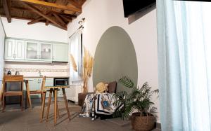 a living room with a table and a kitchen at Lithoessa in Agios Ioannis Kaspaka
