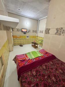 a room with a bed and a tv in it at Happy Hills in Yelagiri