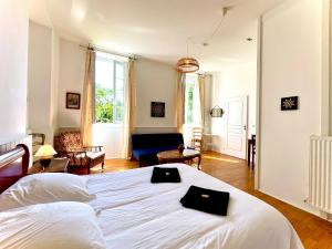 a bedroom with a white bed and a living room at La Demeure des Fleurs in Caillavet +11 photos