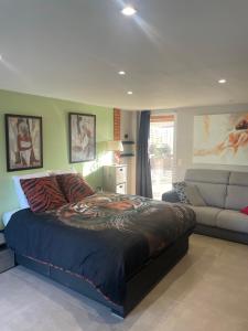 a bedroom with a large bed and a couch at Ô Sens Jacuzzi et Massages in Challans