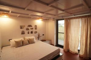a bedroom with a bed and a large window at Mud & Meadows- A Satvik Farmstay, Jamshedpur in Jamshedpur