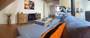 a living room with a blue couch and a kitchen at Zukalka 2KK - 3 in Ostrava