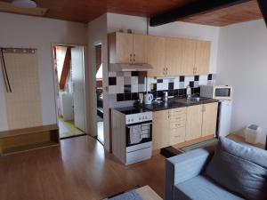 a kitchen with a stove top oven next to a couch at Zukalka 2KK - 3 in Ostrava +13 photos