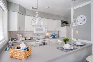 a kitchen with white cabinets and a basket on a counter at Explore Indy in Perfect Location - Cozy 1BR in Indianapolis +9 photos
