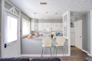 a kitchen with two white chairs and a counter at Explore Indy in Perfect Location - Cozy 1BR in Indianapolis