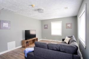 a living room with a couch and a tv at Explore Indy in Perfect Location - Cozy 1BR in Indianapolis