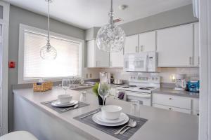 a kitchen with white cabinets and a counter with dishes on it at Explore Indy in Perfect Location - Cozy 1BR in Indianapolis