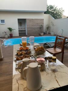 a table with food and drinks on it with a pool at Pousada Recanto Populina in Populina