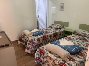 a room with two beds with pillows on them at Pousada Recanto Populina in Populina