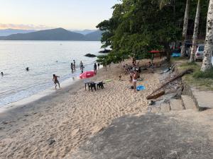 a group of people on a beach near the water at Deck Picinguaba Pousada in Picinguaba +6 photos