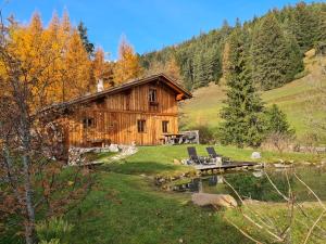 a log cabin with a table and chairs in front of it at Molin in Vigo di Fassa