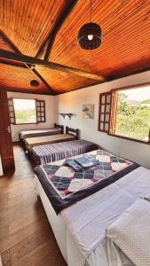 a room with three beds in it with windows at Amazing house with chalet and a beautiful garden in Sêrro