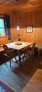 a wooden table and two chairs in a room at Molin in Vigo di Fassa