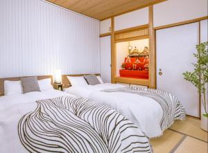 two beds in a room with white walls at Kawaramachi Grande Joy in Takamatsu