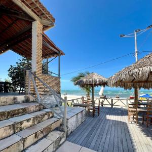 a beach resort with stairs and tables and straw umbrellas at Casa da Juma in Fortim
