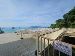 a deck with tables and chairs on the water at Safary Tour in Ban Ta Kun