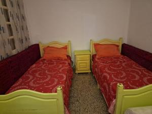 two beds sitting next to each other in a room at Dar Mima in Tunis
